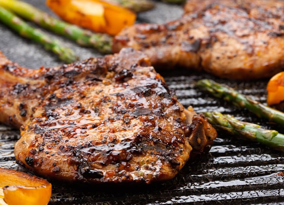 How to Perfectly Grill Pork 6 Pork chops on a grill with asparagus
