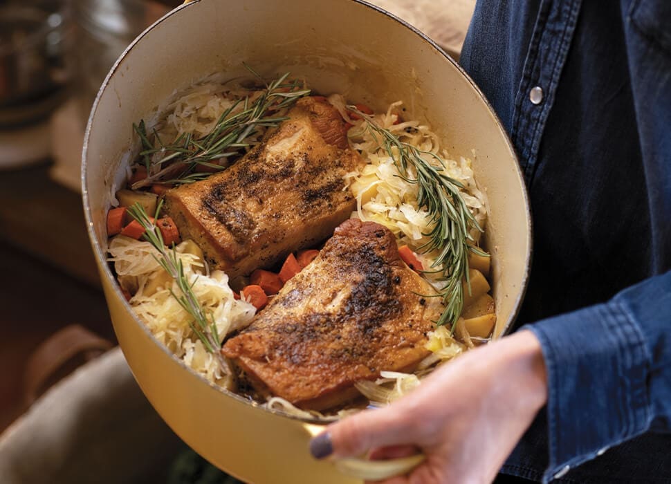 hands holding slowcooker with pork chops