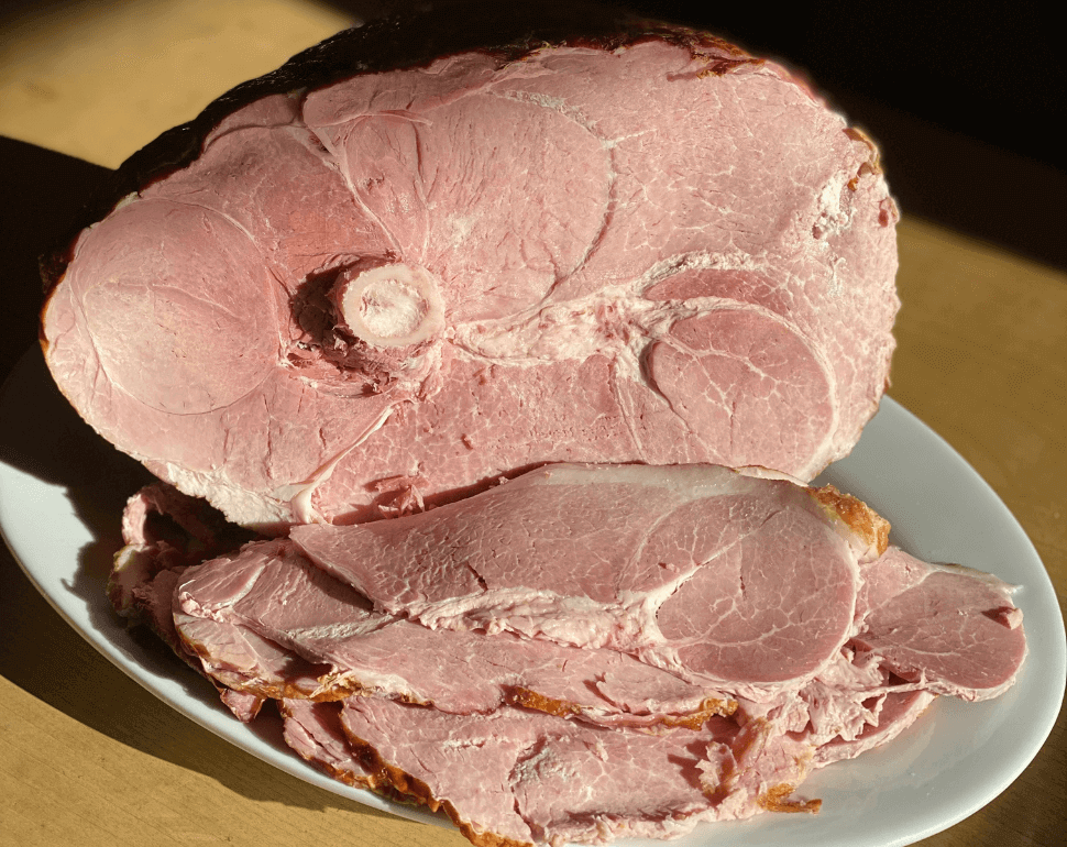 A sliced whole ham on a plate